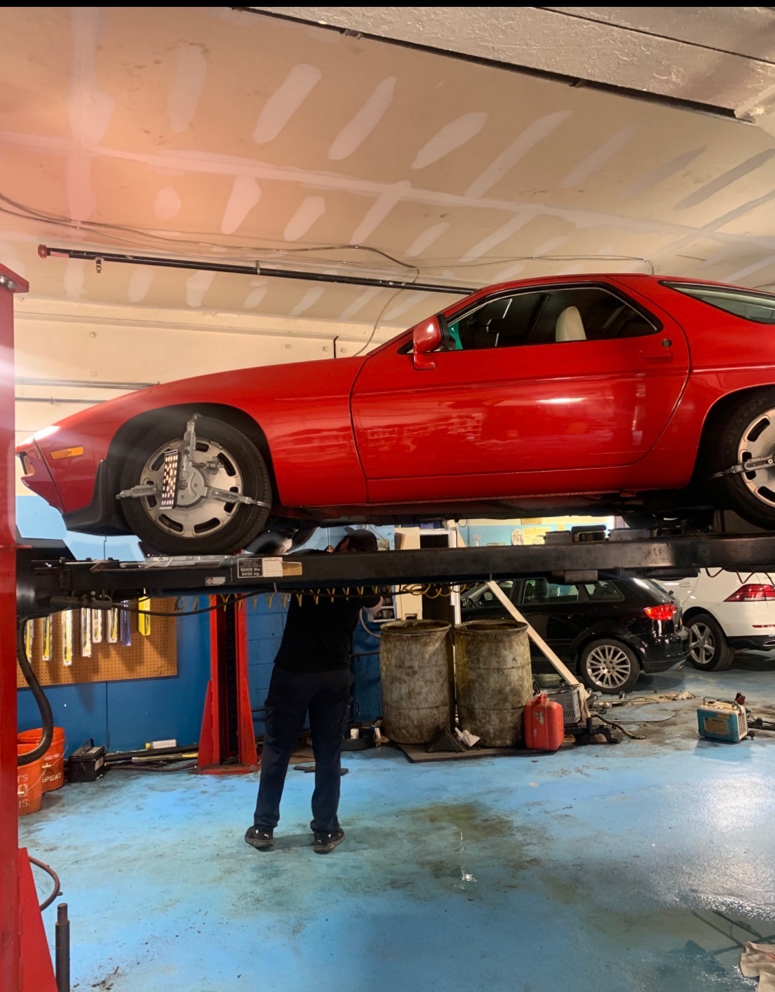 Car raised on a hydraulic lift inside the Foreign Fix Auto Center service bay