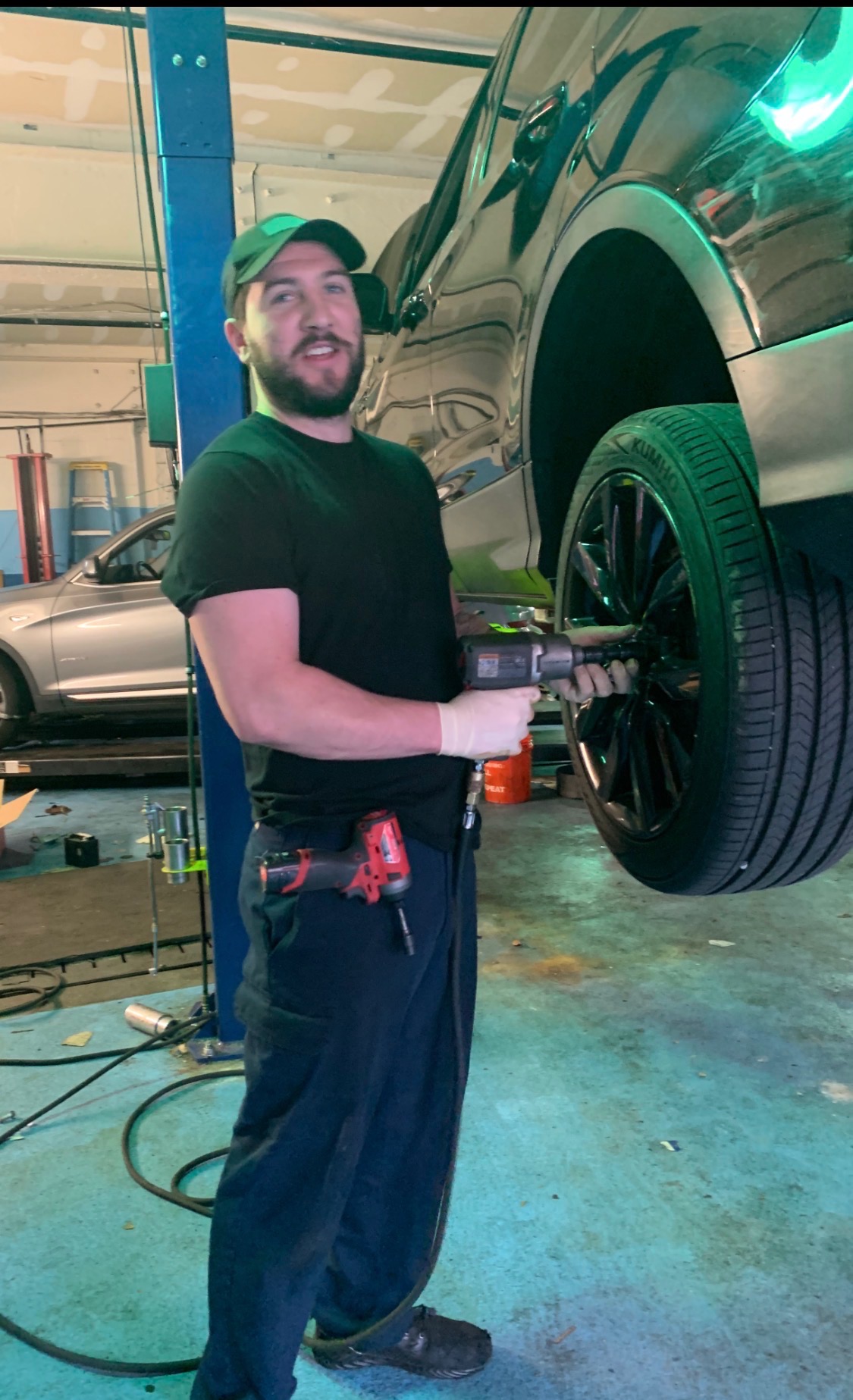 Technician servicing a vehicle wheel and brake assembly at the auto repair shop