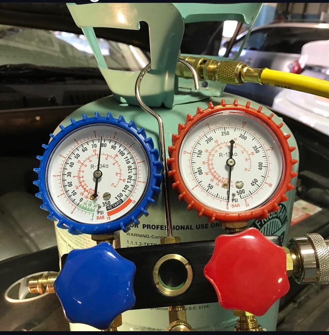 Air conditioning manifold gauge set connected to a vehicle for an A/C diagnosis and recharge